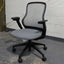 Black office chair with mesh backrest on a concrete floor.