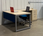 Modern office setup with L-shaped desk, chair, and blue storage unit.