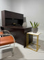 Modern used office desk with chair, plant, and decorative items.