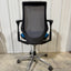 Spree Brand Office Task Chair for Sale Black office chair with mesh backrest on a concrete floor.