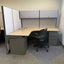 Modern office desk with chair and storage cabinets in a patterned room.